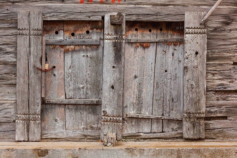 Closed wooden window shutter. Historic village of Mühlebach, Valais, Switzerland, Europe
