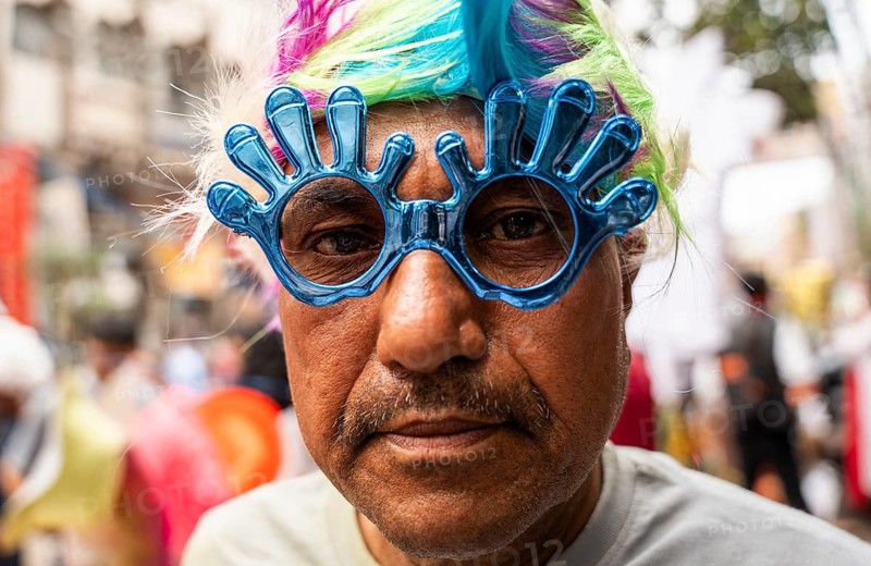 A person wears a holi sunglass in a market on the eve of Holi Festival, on March 13, 2025 in Guwahati, India. Holi is a Hindu festival celebrated mainly in India marking the arrival of spring it is also known as the Festival of colors, as people throw vibrant colored powders at each other, dance, and celebrate with music and sweets