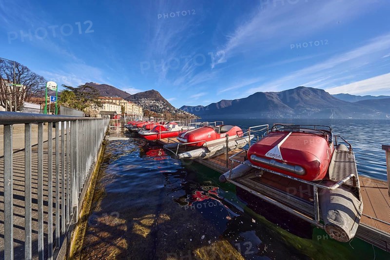 Pedal boats, metal railing, lake, shore, pavement, pedal boat rental, mountain landscape, haze, blue sky, cirrus clouds, veil clouds, Lake Lugano, street Riva Giocondo Albertolli, Lugano, district Lugano, canton Ticino, Switzerland, Europe