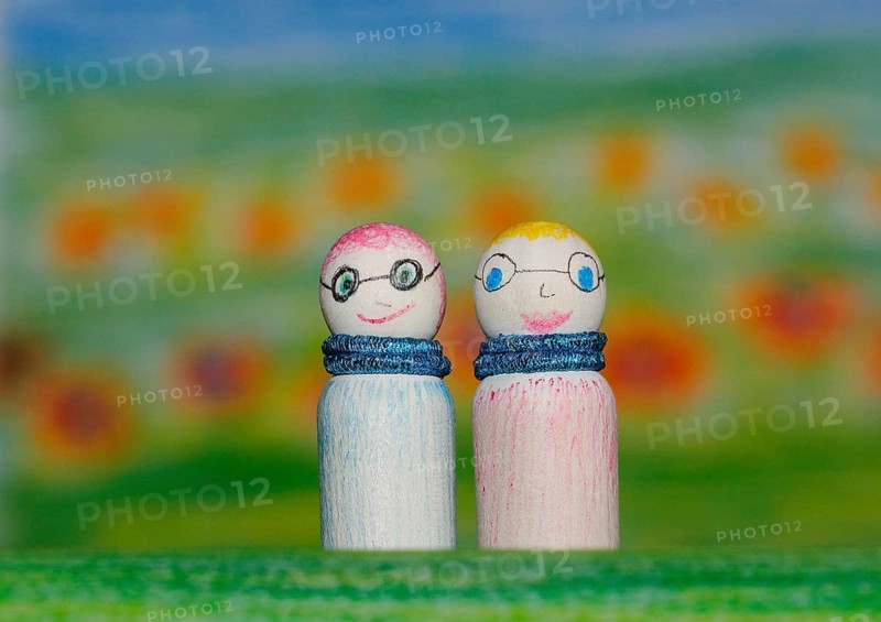 Two small funny wooden cones in front of a painted background, North Rhine-Westphalia, Germany, Europe