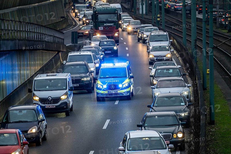 Traffic jam on the A40 motorway, emergency lane, vehicles on the left and right, police patrol car with flashing blue lights and siren, Essen, North Rhine-Westphalia, Germany, Europe