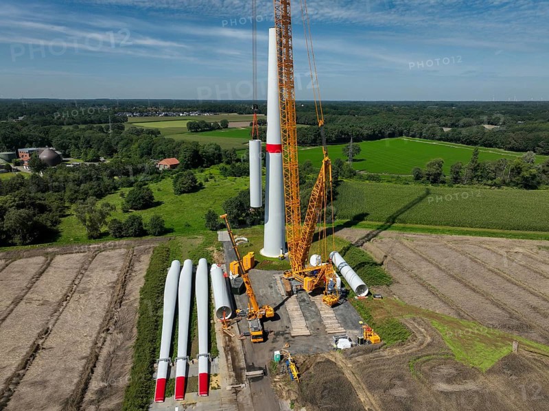 Dorsten, North Rhine-Westphalia, Germany, construction of a wind turbine, the first wind turbine of the Grosse Heide wind farm. The rotor blades are ready for assembly. A large mobile crane places the tower elements, the rings, on top of each other. This wind turbine will have a rated output of 5, 500 kW, Europe