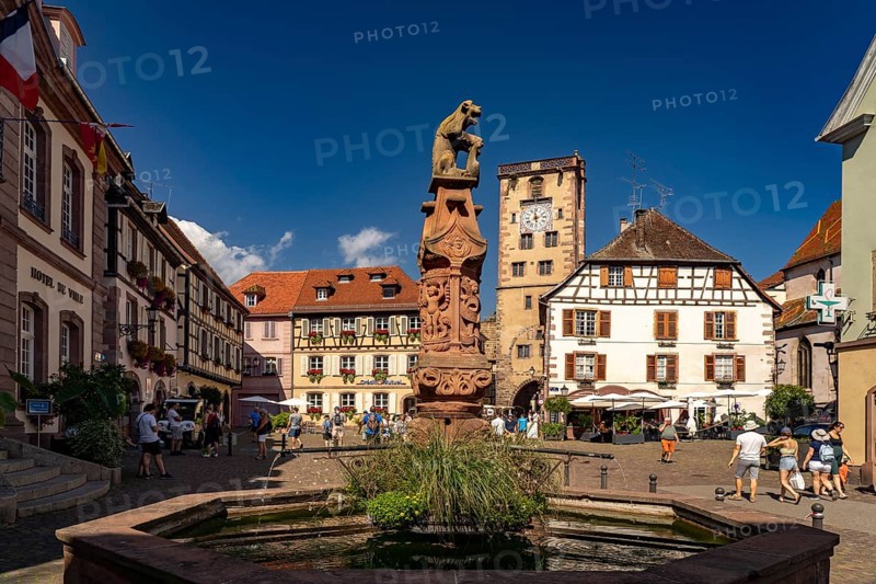 Market fountain in front of the town hall and the butcher's tower in Ribeauville, Alsace, France, Europe
