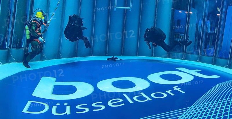 Left diver helmet diver of the German Navy with hose for air supply from outside the water during presentation in diving tower at boot Düsseldorf, in the background right scuba diver, on the ground logo and lettering of Messe boot, Düsseldorf, North Rhine-Westphalia, Germany, Europe