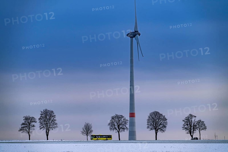 Country road, local train, wind farm, north of Lichtenau, self-proclaimed energy town, over 190 wind turbines and over 1200 solar panels generate 10 times as much electricity as the community of 11, 900 inhabitants consumes, largest onshore cluster of wind turbines in Germany, winter, slightly snow-covered landscape, North Rhine-Westphalia, Germany, Europe
