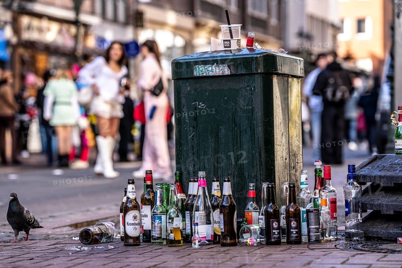 Rose Monday carnival parade in Düsseldorf, old town, empty bottles, various alcoholic beverages, at a rubbish bin, in front of the barriers in the old town, where there is a ban on galloping