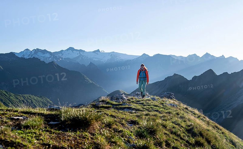 Hiker enjoying the mountain panorama in the morning, Venediger group, behind Dreiherrenkopf, Simonysitze and Großer Geiger, Hohen Tauern, Austria, Europe