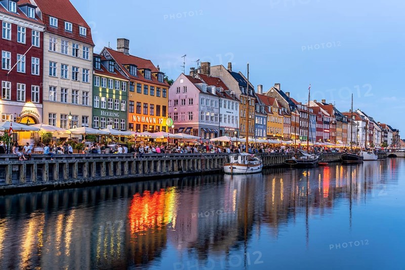 Colourful houses, restaurants and historic ships on the Nyhavn canal and harbour at dusk, Copenhagen, Denmark, Europe