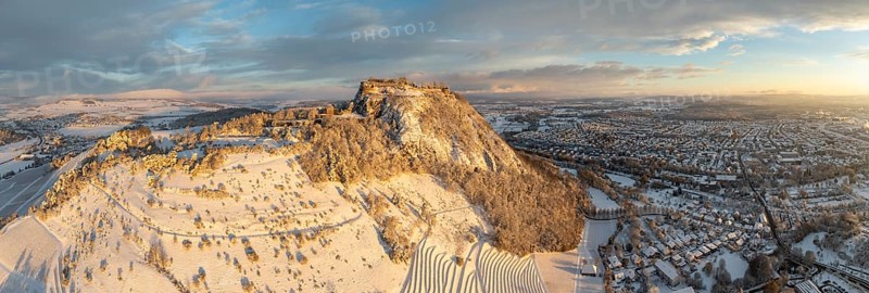 Aerial view, panorama of the snow-covered Hegau volcano Hohentwiel with Germany's largest castle ruins on a cold winter morning, at sunrise, in front of it Germany's highest vineyard, the Elisabethenberg at 505 metres above sea level, on the right the town of Singen, district of Constance, Baden-Württemberg, Germany, Europe