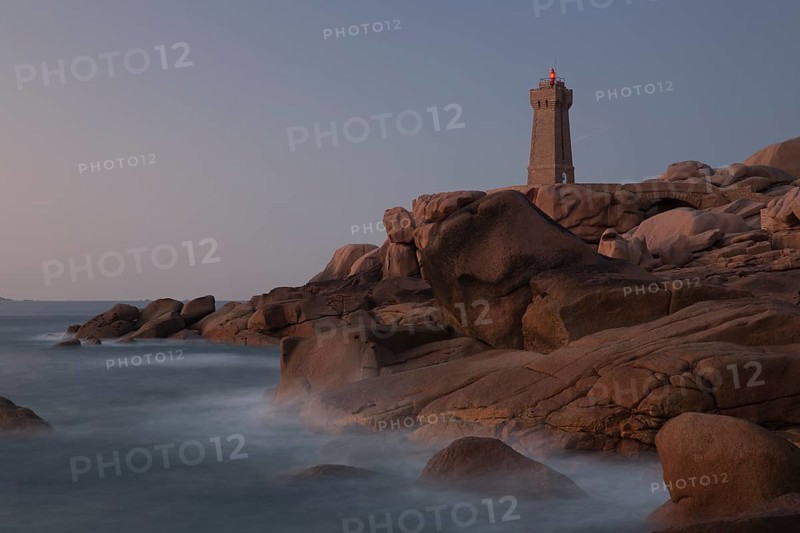 Lighthouse Mean Ruz at Ploumanach, Cotes d'Armor in the last evening light, with light on