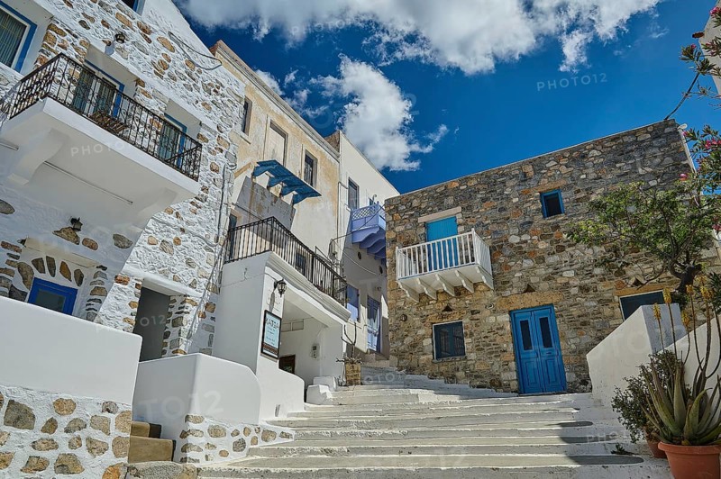 Stone and plaster houses on a picturesque staircase with a bright blue sky in the background, Chora, Astypalea, Dodecanese, Greek Islands, Greece, Europe