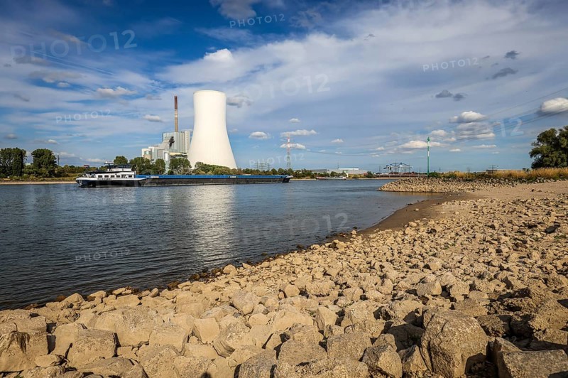 Rheinberg, Duisburg, North Rhine-Westphalia, Germany, Dry, stony riverbed in the Rhine with STEAG hard coal-fired power station Walsum at the Orsoy ferry landing stage, Rhine ferry Walsum-Orsoy. After a long dry spell, the level of the Rhine continues to fall. Freighters can only navigate the Rhine with small loads because of the draught. Freighters, here freighter ALEXANDRA, park in front of the entrance to Duisburg harbour due to the low water level, Europe