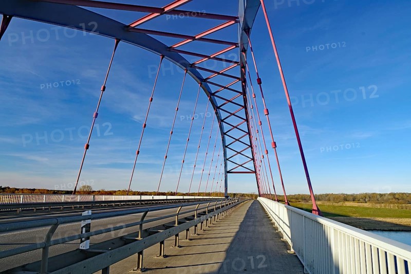 A modern steel bridge with pink and white struts spans a long distance under a clear sky, symbol of German unity, Dömitzer Brücke, Wendland, Lower Saxony, Mecklenburg-Western Pomerania, Germany, Europe