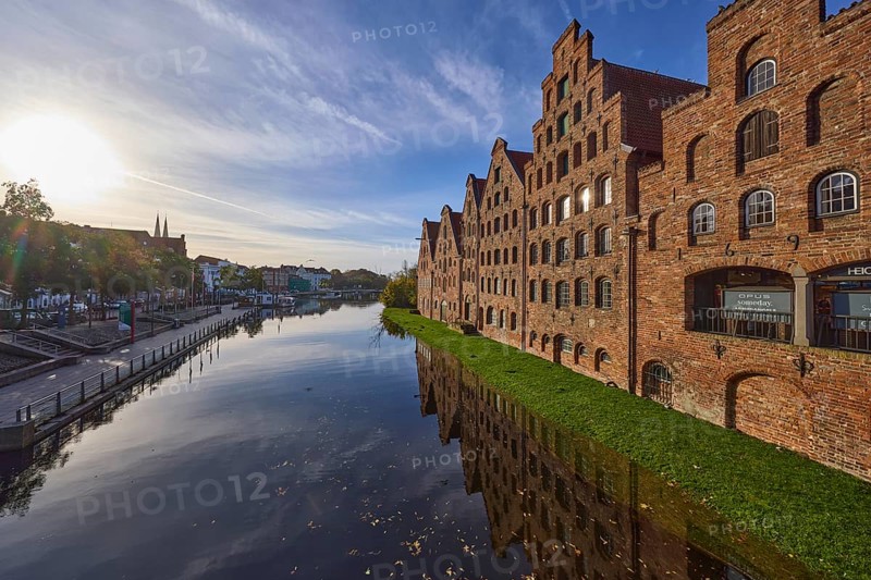 Historic salt warehouses, river Trave, blue sky with veil clouds in the backlight of the sun, Hanseatic city of Lübeck, independent city, Schleswig-Holstein, Germany, Europe