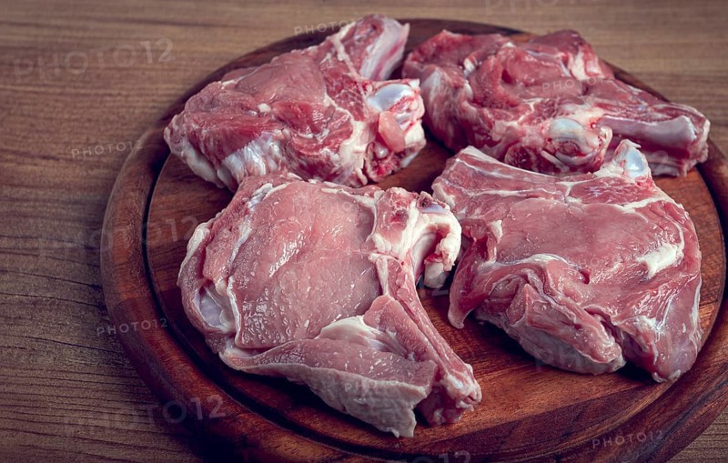 Raw calf meat, meat on the bone, meat for barbecue, cutting board, top view
