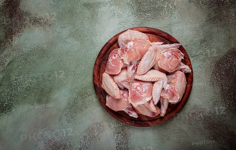Raw chicken wings, on a wooden board, top view, no people
