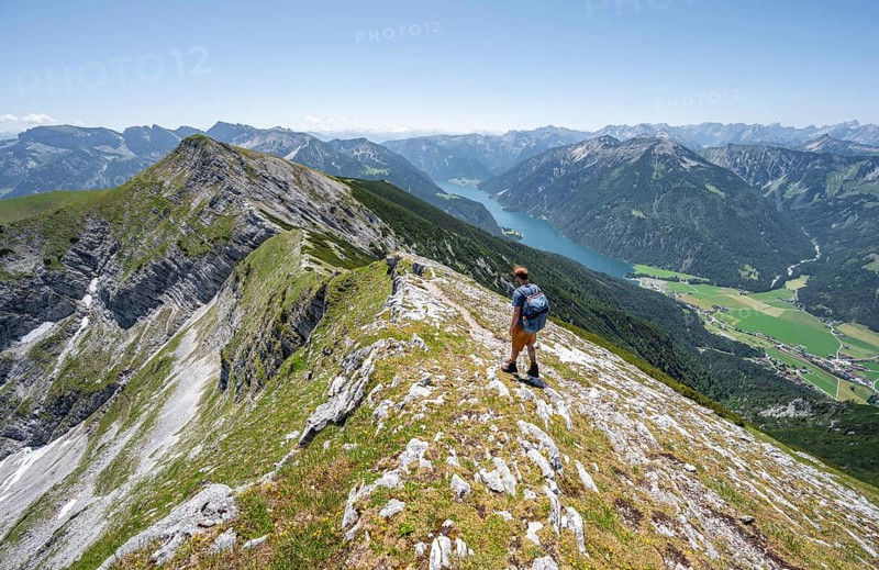 Mountaineer on the summit ridge of the Unnütz, behind Achensee and summit of the Seekarspitze Unnütz crossing, Brandenberg Alps, Tyrol, Austria, Europe