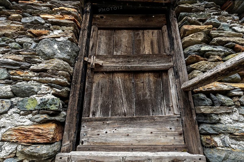 Old wooden door of a typical Ticino stone house in the mountain village of Bordei, Centovalli, Canton Ticino, Switzerland, Europe
