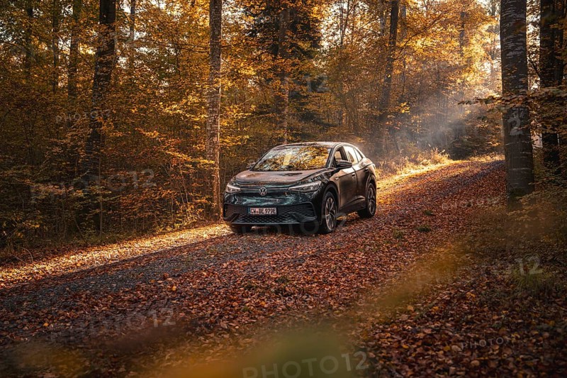 Car on a secluded forest path, surrounded by autumn leaves and golden light, electric car VW ID5, Gechingen, Black Forest, Germany, Europe
