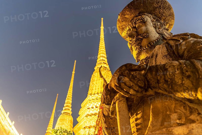 Giant Farang Guard and Chedi of the Buddhist temple Wat Pho at dusk, Bangkok, Thailand, Asia