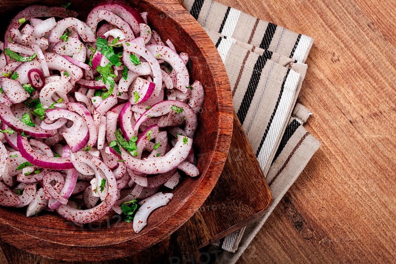 Chopped red onion, with sumac and herbs, in a bowl, pickled Spanish onion, close-up, top view