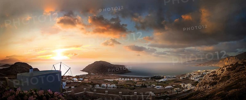 Sweeping panoramic view of the coastal landscape from the town of Arkasa and windmill at sunset, Arkasa, Karpathos, Greece, Europe
