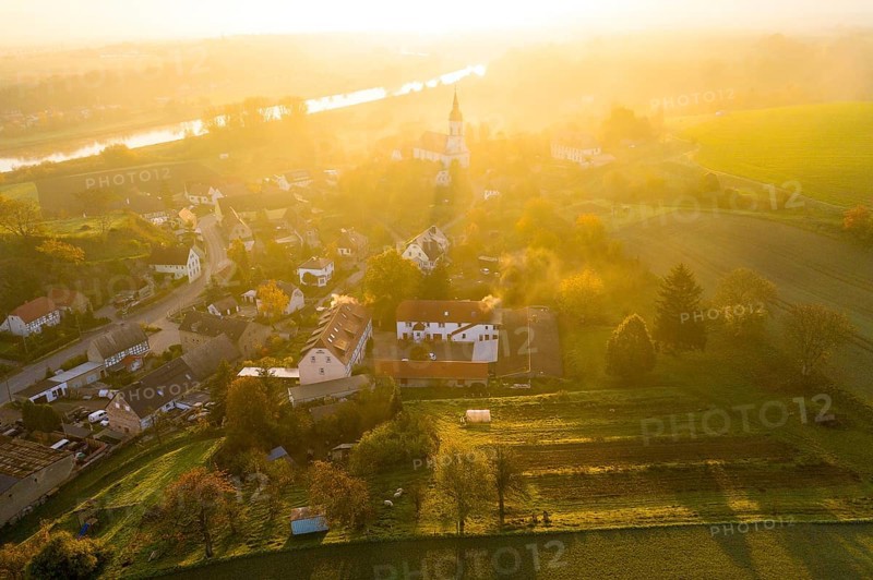 Aerial view, view of the village with St Michael's Church at sunrise, church casts a long shadow, the Elbe in the background, Zehren, Saxony, Germany, Europe