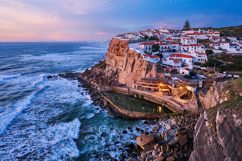 Scenic view of the seaside Azenhas do Mar fishing village on cliff on Atlantic ocean coast, Portugal in evening twilight dusk