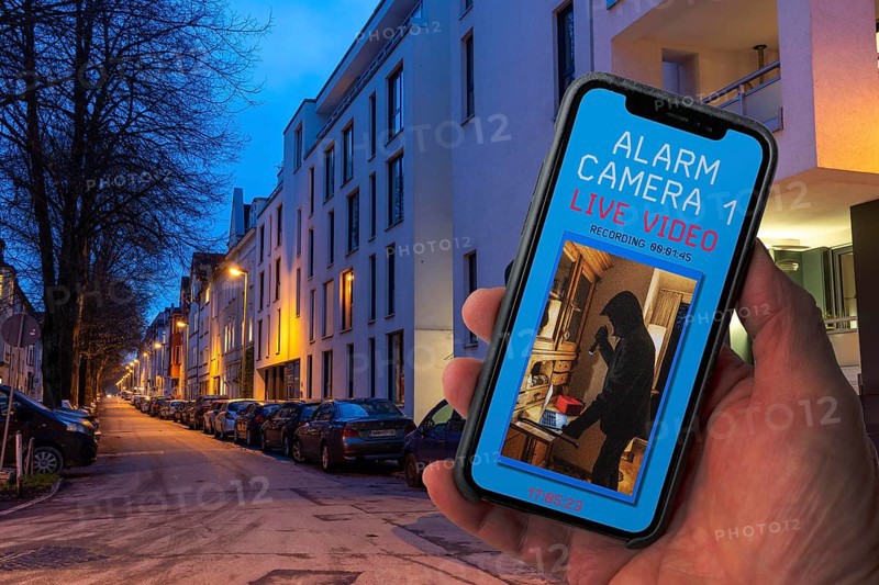 Symbolic image of burglary, burglary video app, shows the live image from a flat while a burglar is in the rooms, video camera transmits the image live to the mobile phone and records the images, motion detector triggers the camera and immediately sends a push message to the mobile phone, North Rhine-Westphalia, Germany, Europe