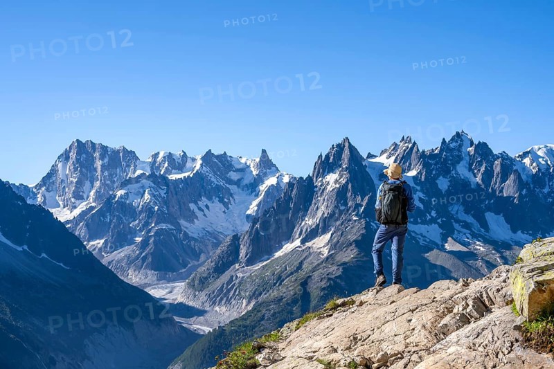 Mountaineer on a hiking trail in front of a mountain landscape, view of the mountain peaks Grandes Jorasses and Mer de Glace, Mont Blanc massif, Aiguilles Rouges, Chamonix-Mont-Blanc, Haute-Savoie, France, Europe
