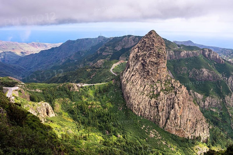 View of the Roque de Agando rock tower, one of La Gomera's landmarks, from the Mirador del Morro de Agando. During the day, sun and clouds. Monumento Natural de Los Roques, La Gomera, Canary Islands, Spain, Europe