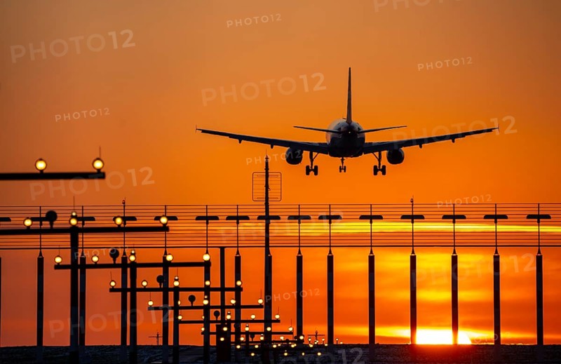 Aircraft approaching the main runway south, 05R/23L, runway lighting, approach aids, at Düsseldorf International Airport, sunset, North Rhine-Westphalia, Germany, Europe