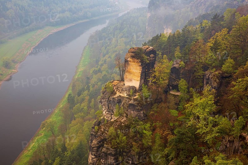 The bright lit Wartturm above the Elbe river seen from the Bastei rocks near the village of Rathen in Saxon Switzerland National Park, Saxony, Germany. On November 22, 2000 the Wartturm was the scene of a spectacular rockfall