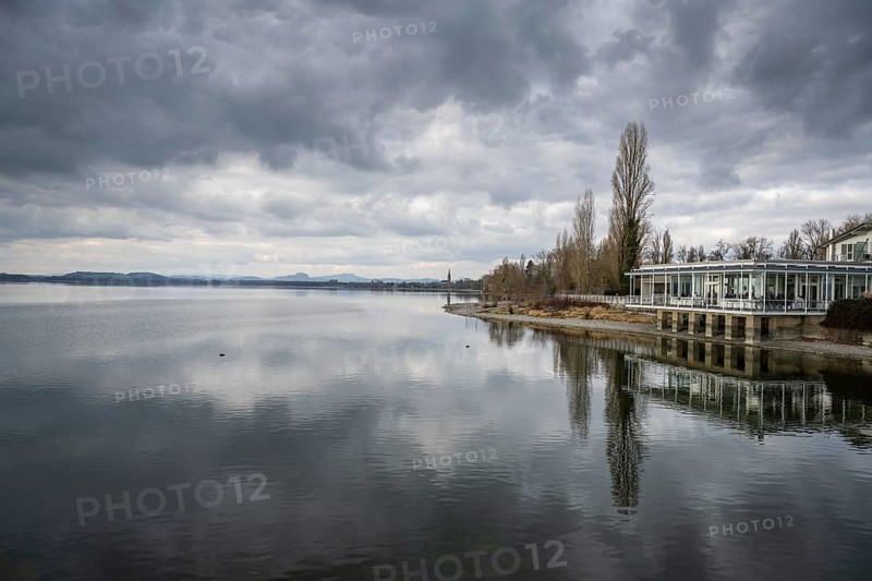 View over Lake Constance, on the right the Strandcafe restaurant on the Mettnau peninsula, on the horizon the Hohentwiel and Hohenstoffeln mountains, district of Constance, Baden-Württemberg, Germany, Europe