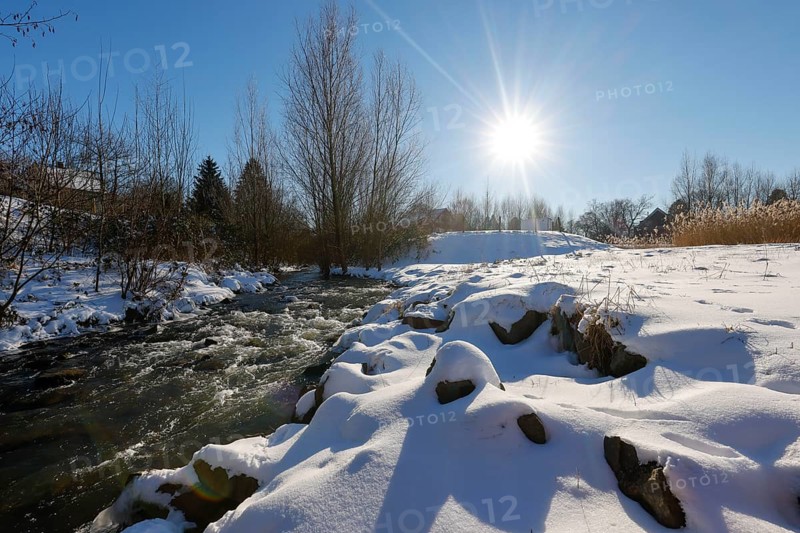 Dortmund, North Rhine-Westphalia, Germany - Sunny winter landscape in the Ruhr area, ice and snow on the renaturalised Emscher, the ecological conversion of the Emscher system consists of the construction of a central wastewater treatment system in the Ruhr area, the construction of underground sewers and the renaturalisation of the Emscher and its tributaries