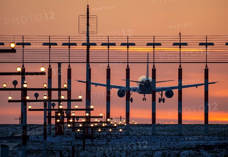 Aircraft approaching the main runway south, 05R/23L, runway lighting, approach aids, at Düsseldorf International Airport, sunset, North Rhine-Westphalia, Germany, Europe