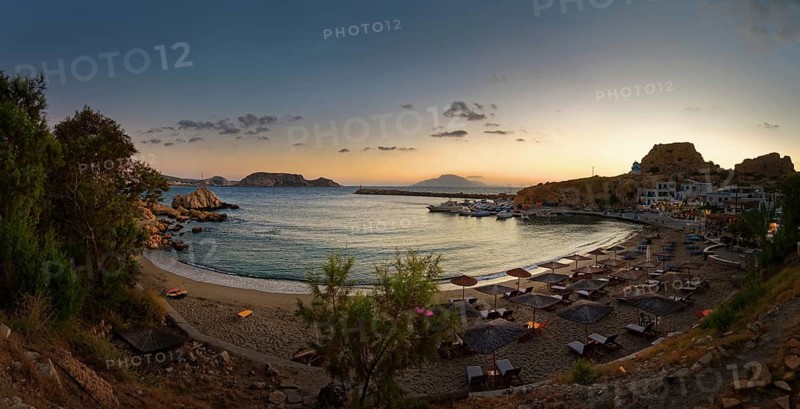 Beach of the fishing village Finiki with parasols and the sea in a quiet evening mood, Finiki, Karpathos, Greece, Europe