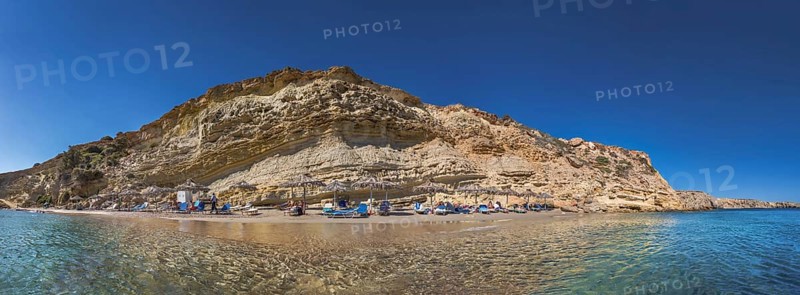 Rocky coastal landscape with Paralia Agios Theodoros sandy beach and sunshades in front of a clear sea, Arkasa, Karpathos, Greece, Europe
