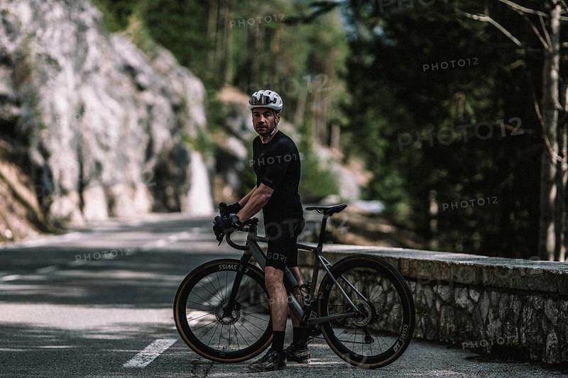 Road bike rider in spring between Lechtal and Tannheimer Tal in front of picturesque scenery of the Alps, Tyrol, Austria, Europe