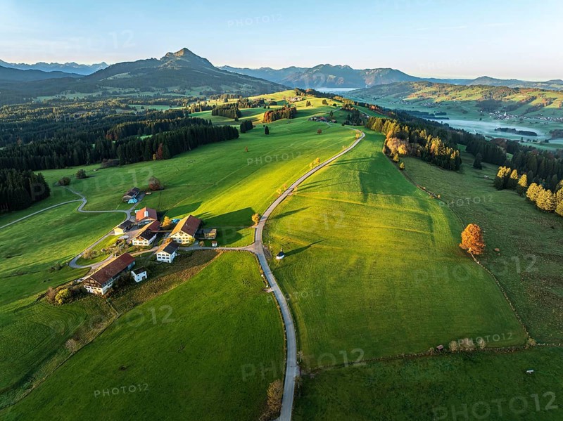 Mountain range near village Wertach, view to mt. Gruenten, sunrise, fog in valley, autumn colors, traditional farm, aerial view, Allgaeu, Bavaria, Germany, Europe