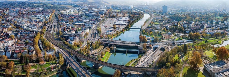 Stuttgart and the Neckar valley, with the Bad Cannstatt district and railway station on the left. In the centre of the picture the Wasen, above it the headquarters of Mercedes-Benz Group AG, the Mercedes Museum and the MHP Arena. Railway bridges over the Neckar. Aerial view, panoramic photo. Stuttgart, Baden-Württemberg, Germany, Europe