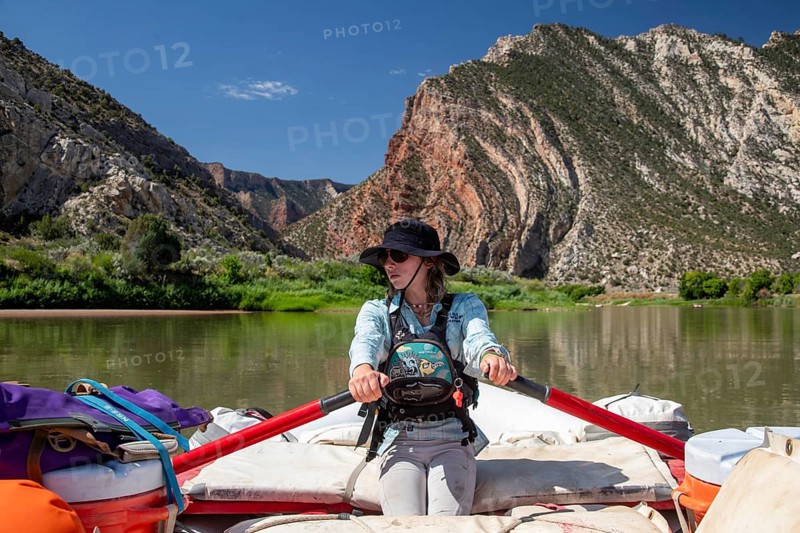 Dinosaur, Colorado, River guide Abbey Woodruff rows her raft on the Green River in Dinosaur National Monument. She is in Rainbow Park, just above Split Mountain Canyon