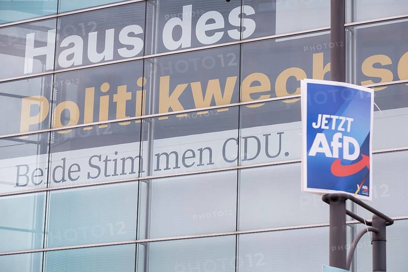 An election poster for the far-right AfD party (now AfD) hangs in front of a large banner with the inscription Haus des Politikwechsels. Both votes CDU. in front of the Konrad Adenauer House. Just after the 80th anniversary of the liberation of the Auschwitz concentration camp, CDU chairman Friedrich Merz tabled a motion in favour of a stricter migration policy, which was only won thanks to the votes of the AfD. Berlin, 01.02.2025