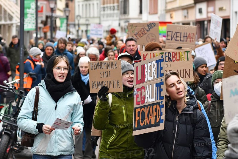 Heidelberg, Germany - February 12th 2025: Young people holding up signs in crowd at protest against far-right