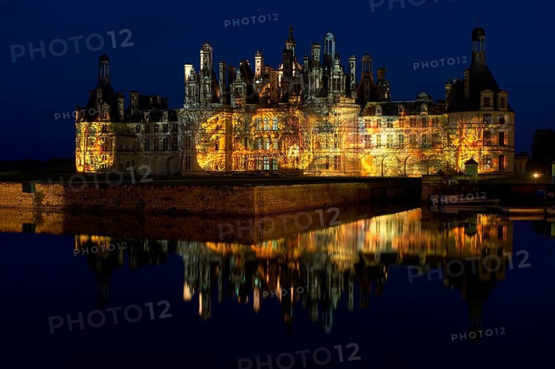 Chambord Castle with summer evening light show and moat, Chambord, Loir-et-Cher department, Centre region, France, Europe