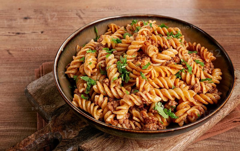 Pasta in the navy, pasta with minced meat, plate on a wooden table, homemade, fusilli pasta, without people