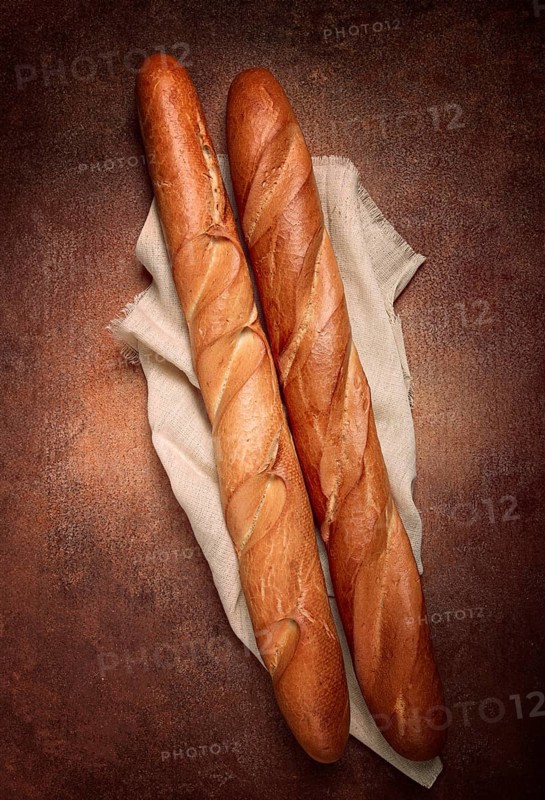 Fresh French baguette, two pieces, top view, on the table, no people
