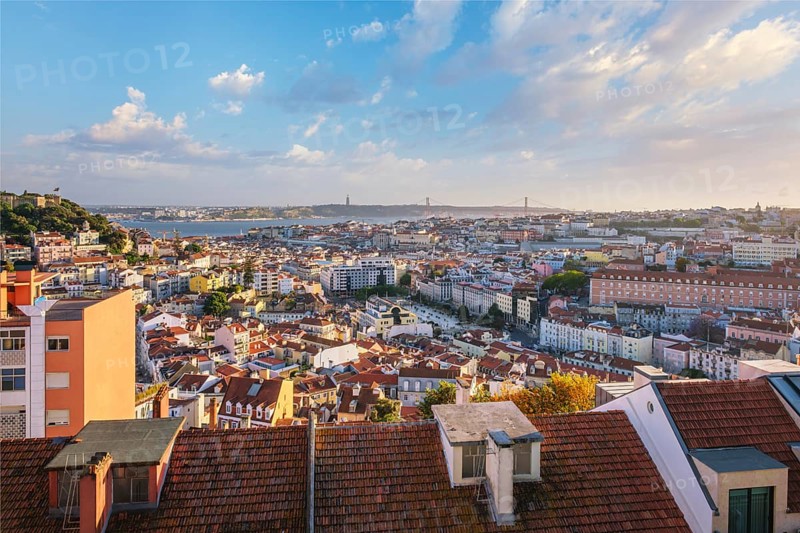 View of Lisbon famous view from Miradouro da Senhora do Monte tourist viewpoint of Alfama and Mauraria old city districts, 25th of April Bridge on sunset. Lisbon, Portugal, Europe