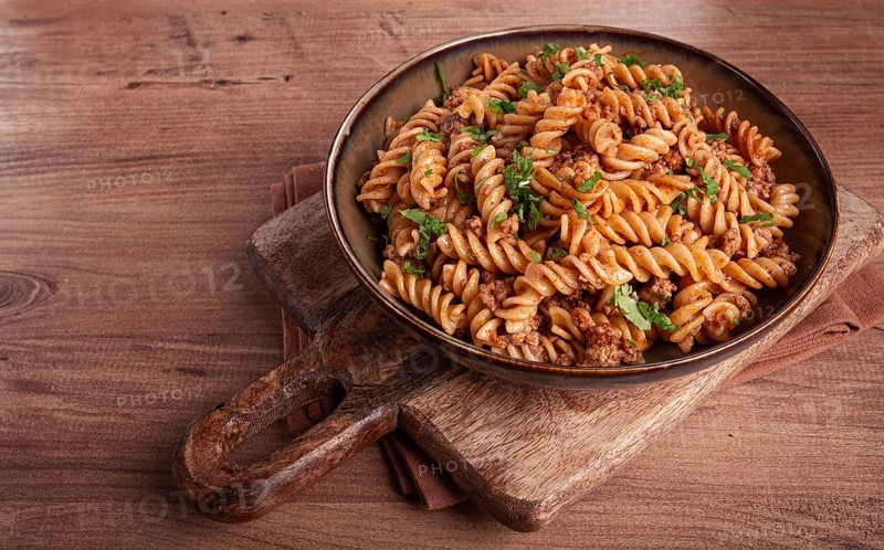 Pasta in the navy, pasta with minced meat, plate on a wooden table, homemade, fusilli pasta, without people