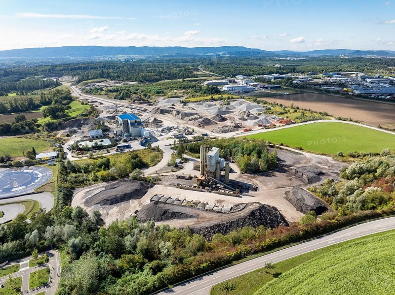 Aerial view of a gravel pit, gravel extraction area, gravel works, asphalt mixing plant and building materials warehouse in the Steißlingen industrial estate and business park, Hegau, district of Constance